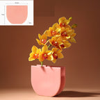 Pink planter with yellow flowers on a brown background