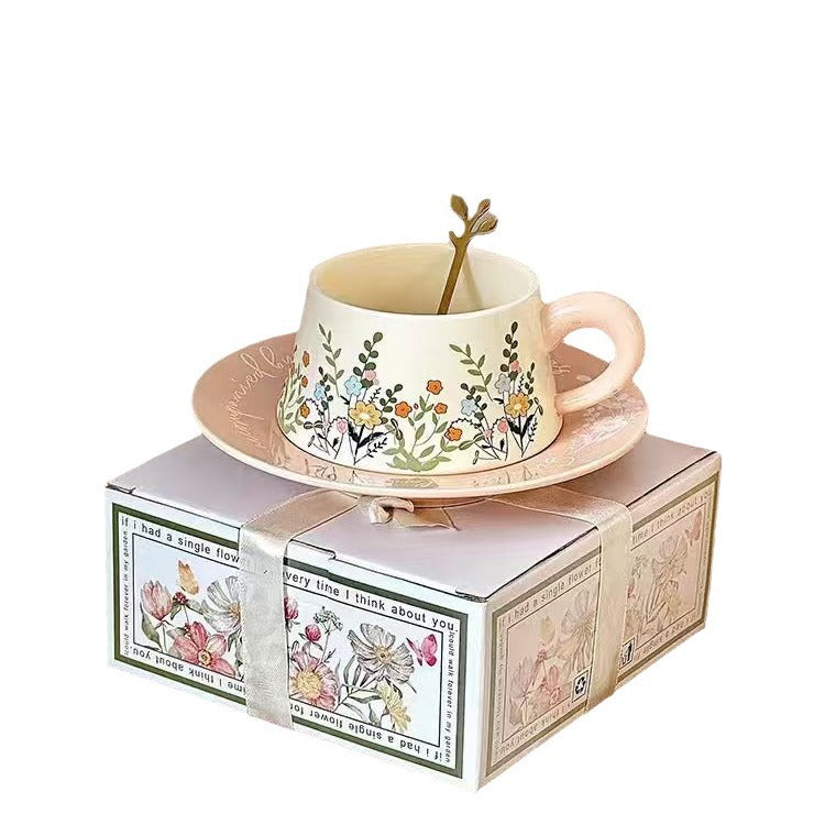 Decorative teacup with floral design on a saucer, placed on a matching box with floral patterns.