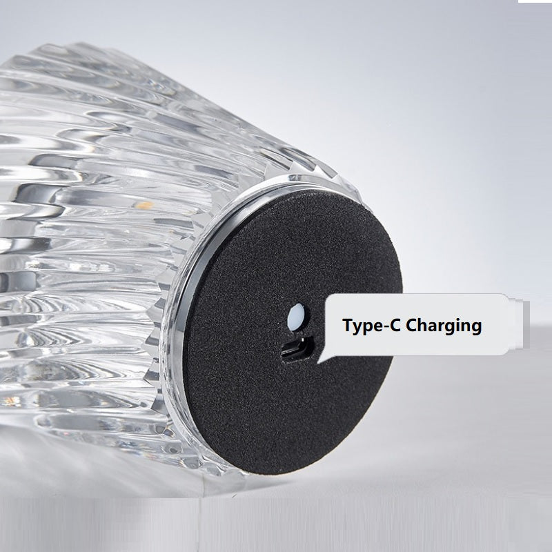 Clear cylindrical device with black charging port labeled 'Type-C Charging' on a light gray background