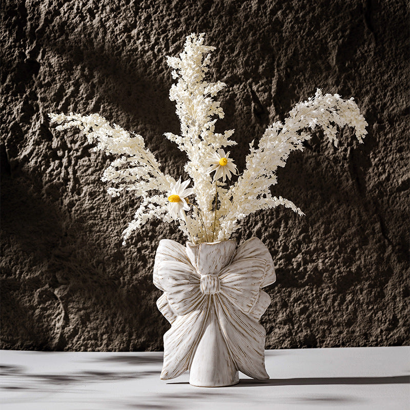 Bow knot ceramic vase styled with dried flowers in minimalist home decor setting