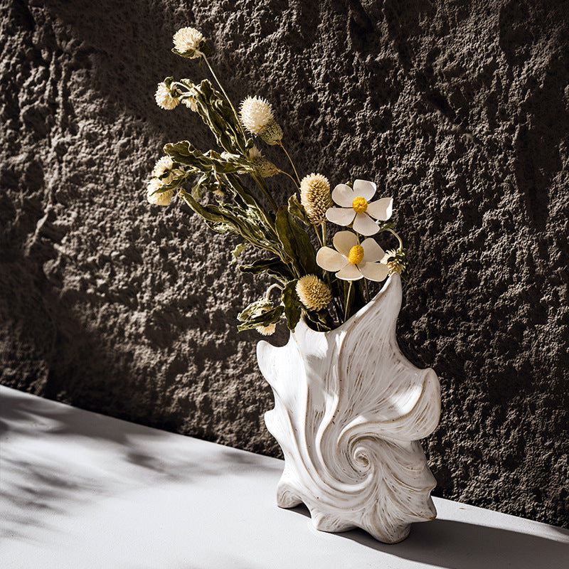 Modern white shell-shaped ceramic vase with sculptural spiral texture for coastal home decor