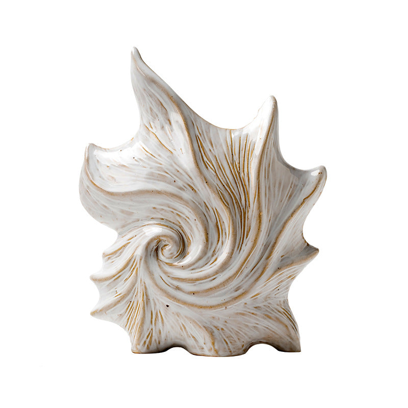 Decorative shell sculpture with gold accents on a white background