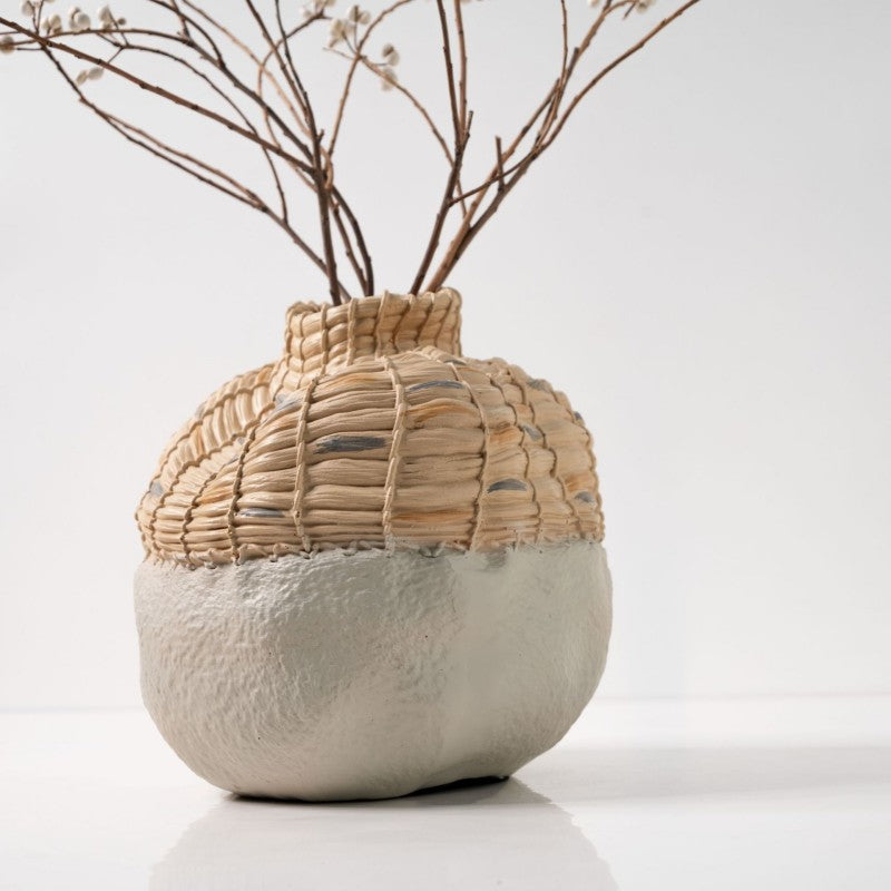 Vase with woven top and textured base on a white background